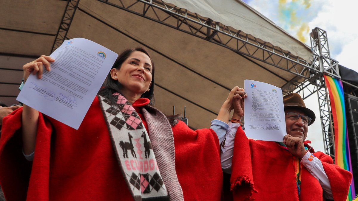 a candidata del correísmo a la Presidencia de Ecuador, Luisa González (i), y el coordinador nacional del movimiento Pachakutik (PK), Guillermo Churuchumbi, sostienen el pacto firmado.