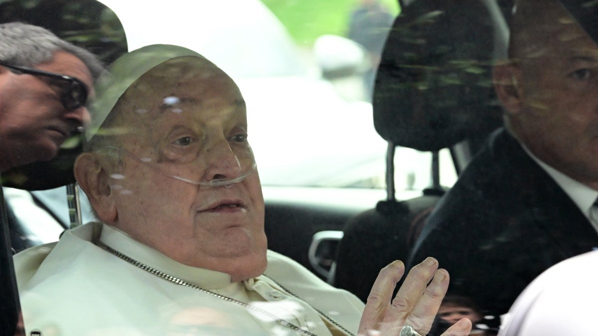 El Papa Francisco saluda al salir en coche del hospital Gemelli tras una hospitalización de cinco semanas por neumonía, en Roma, el 23 de marzo de 2025.