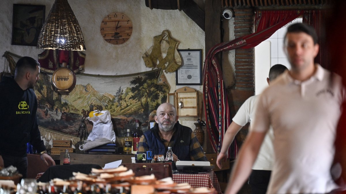 El propietario, Miodrag Nikolic, sentado a una mesa en el restaurante Ethno House, en la ciudad de Gracanica, un enclave serbio a las afueras de Pristina, la capital.