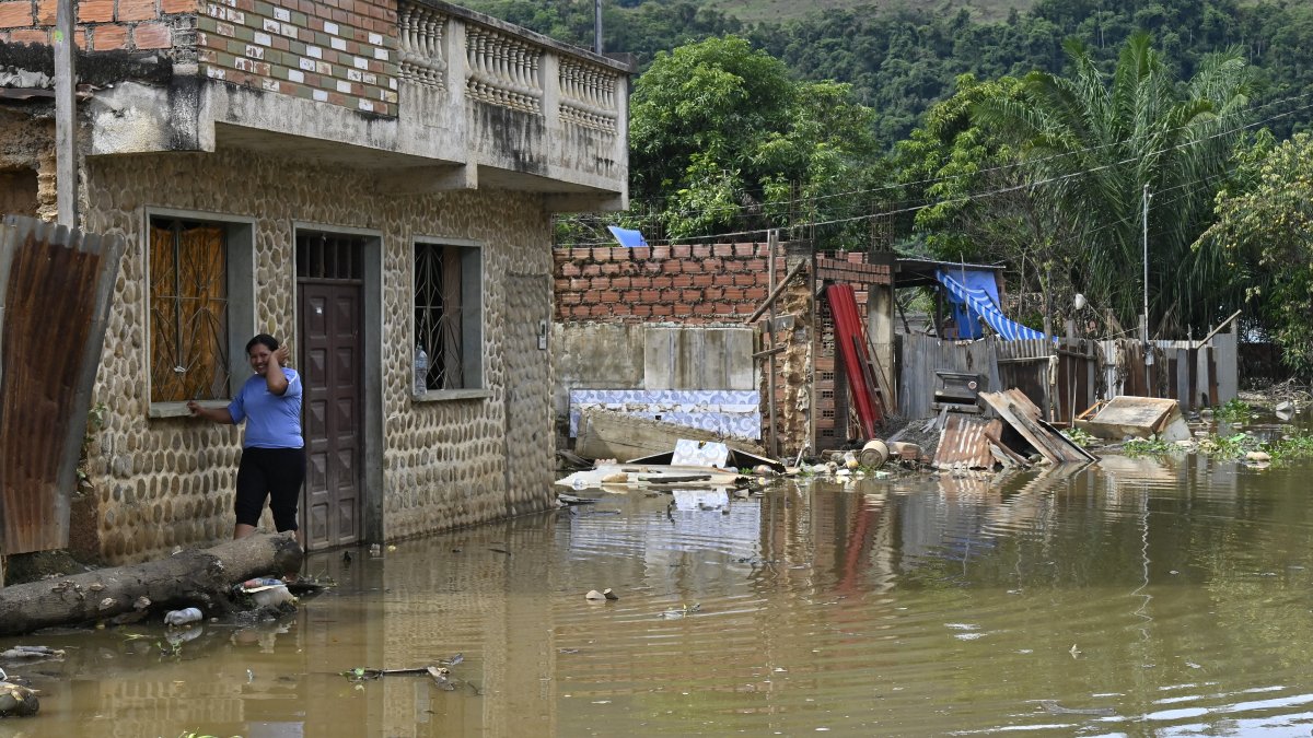 Una mujer camina por una calle inundada en Tipuani tras las fuertes lluvias en el norteño departamento de La Paz, Bolivia.