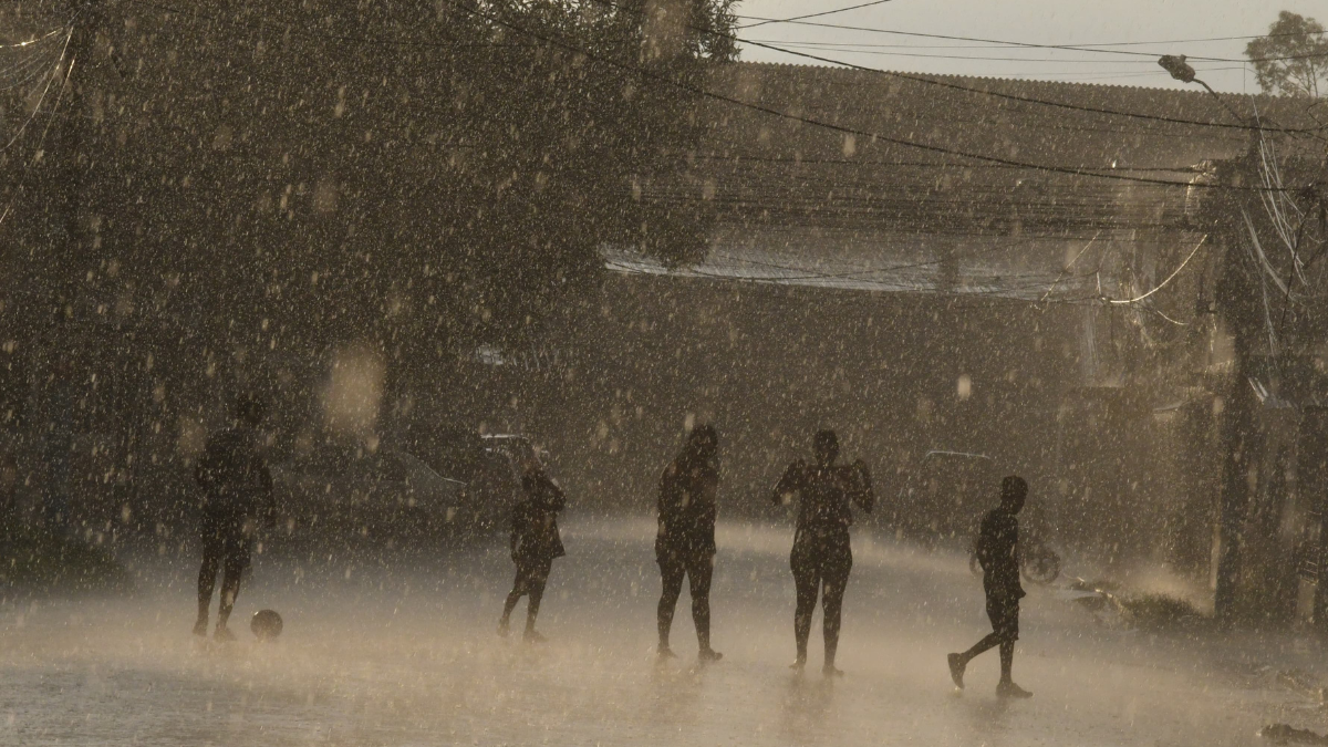 Niños juegan en la lluvia en Guayaquil.