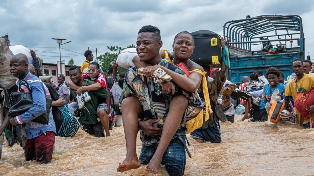 Damnificados atraviesan zonas inundadas tras las intensas lluvias registradas en la República Democrática del Congo.