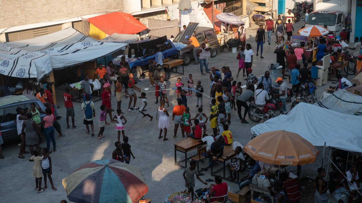 Fotografía de archivo de varios niños y sus familias viviendo en una escuela en Puerto Príncipe (Haití).
