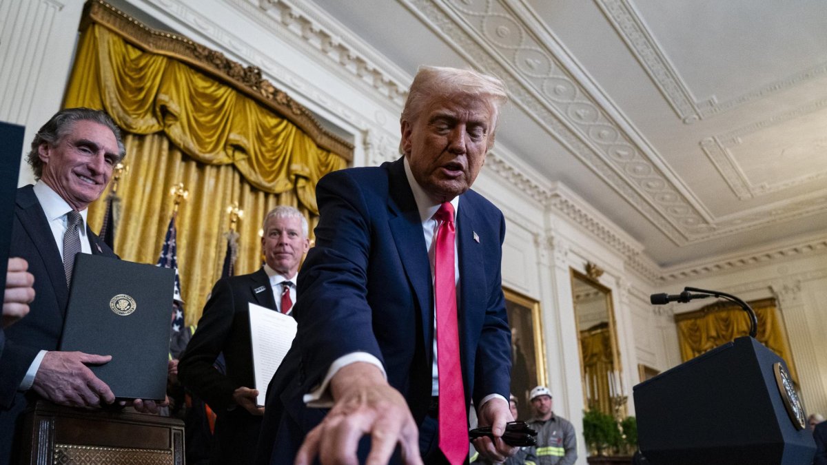 El presidente de Estados Unidos, Donald Trump, reparte bolígrafos después de firmar órdenes ejecutivas durante una ceremonia en la Sala Este de la Casa Blanca.