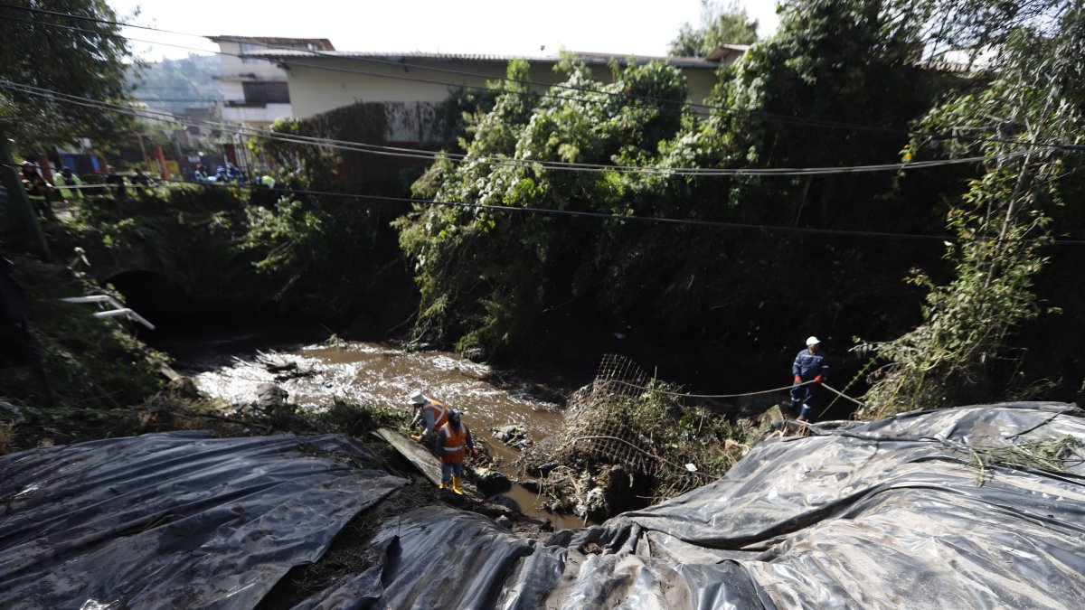 Los trabajadores municipales cubrieron parte del talud que rodea a una de las quebradas que se desbordaron por las fuertes lluvias en Quito.