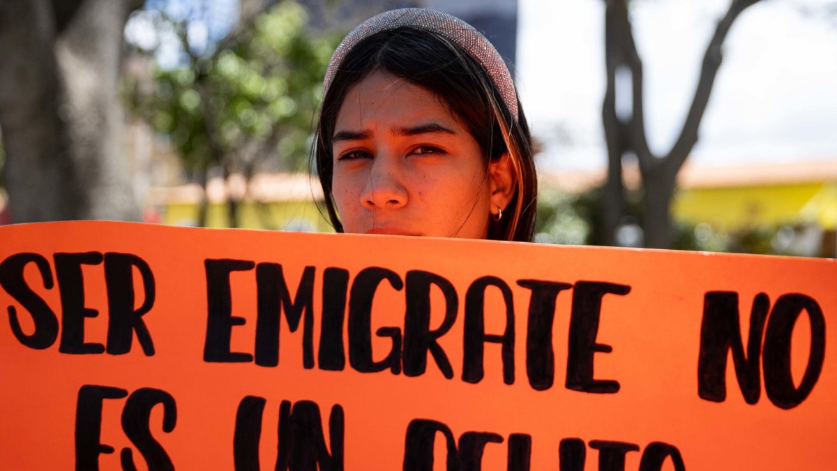 Una mujer sostiene un cartel durante una manifestación en apoyo a la migración.