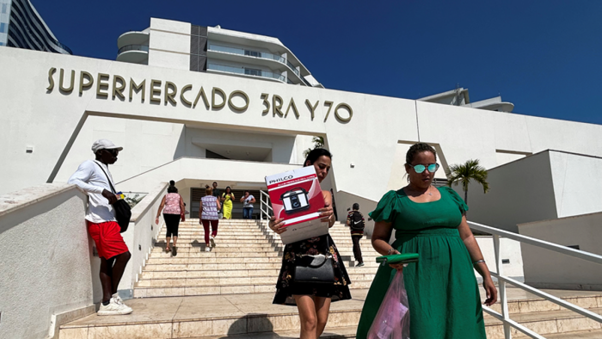Cubanos salen del nuevo supermercado en dólares en La Habana.