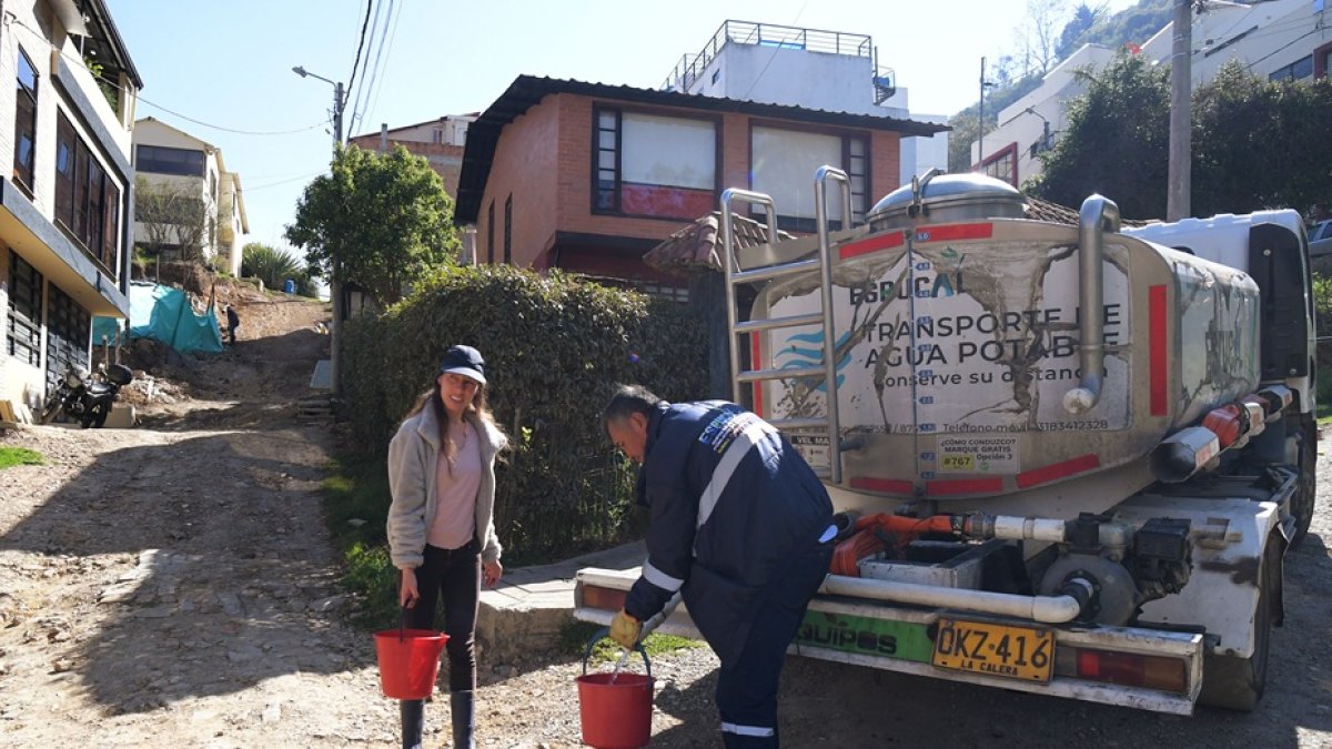 Bogotá. Clara Escobar recoge agua potable de un camión cisterna.