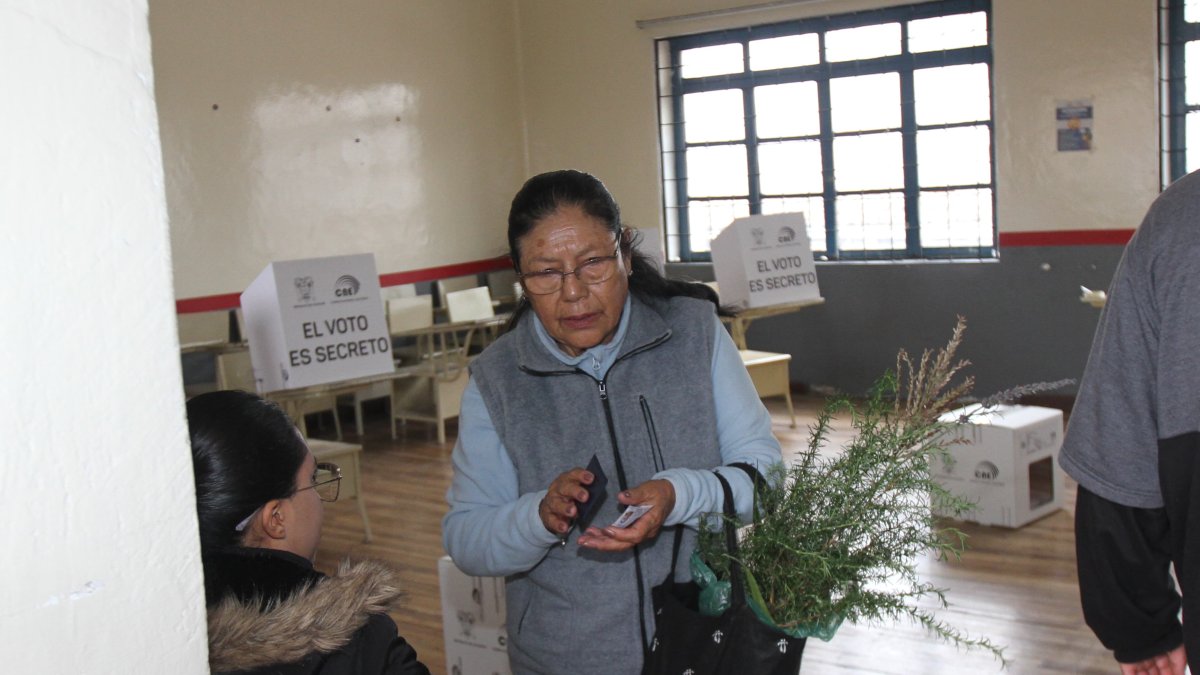 Ciudadanos quiteños acuden a votar con ramos en mano durante el Domingo de Ramos, combinando fe y deber cívico.