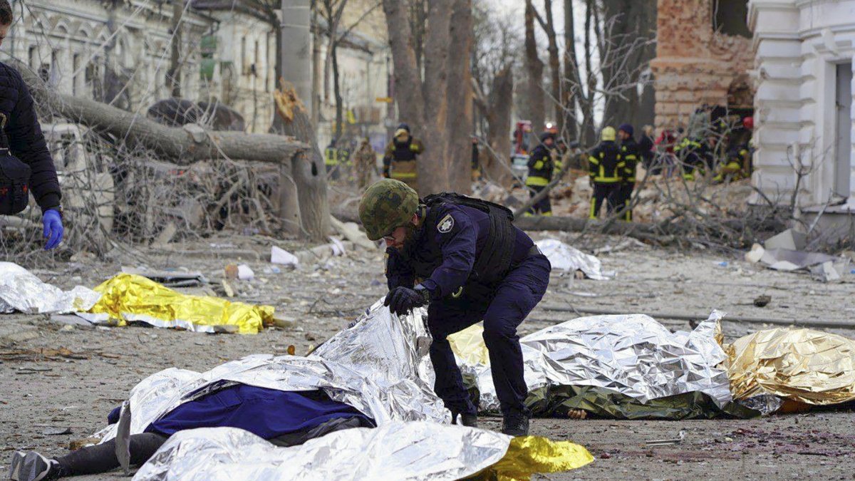 Un policía inspecciona los cuerpos de las víctimas del ataque ruso con misiles balísticos contra el centro de la ciudad nororiental de Sumi, Ucrania, el 13 de abril de 2025.