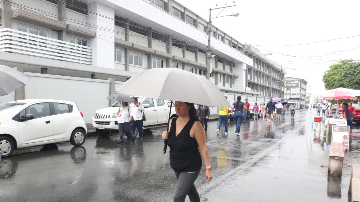 Personas salieron a votar con sus paraguas.