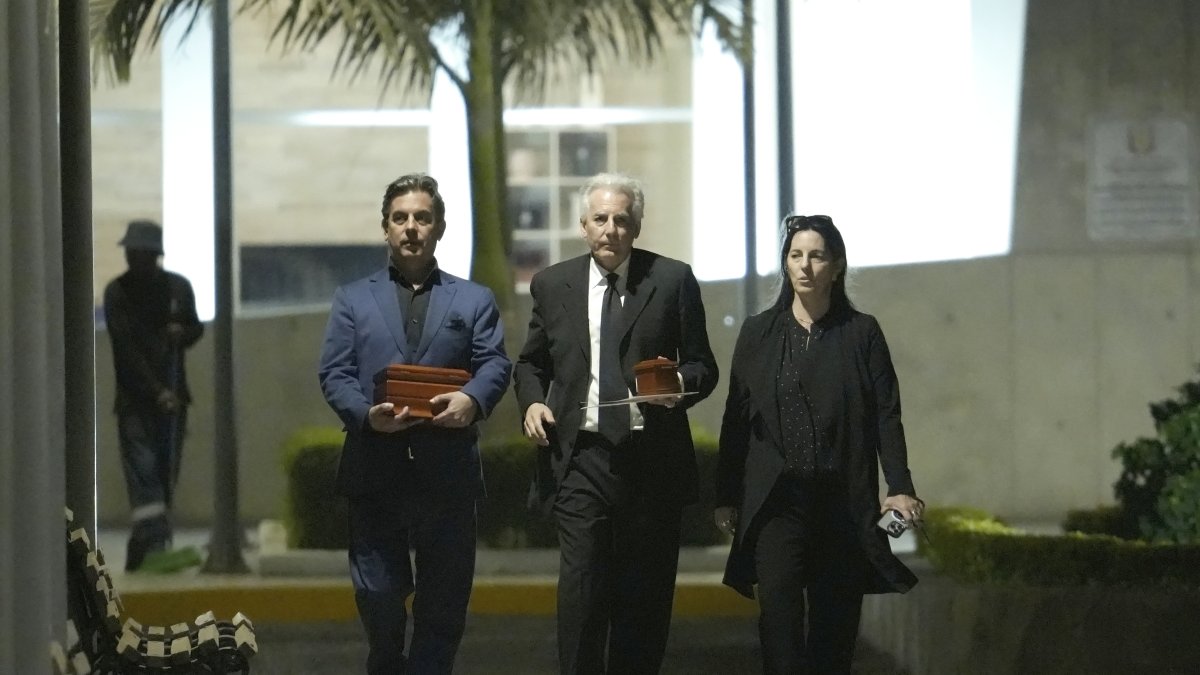 Gonzalo, Álvaro y Morgana Vargas Llosa, hijos del escritor peruano, portan dos urnas con los restos de su padre afuera del Centro Funerario y Crematorio del Ejército de Chorrillos.