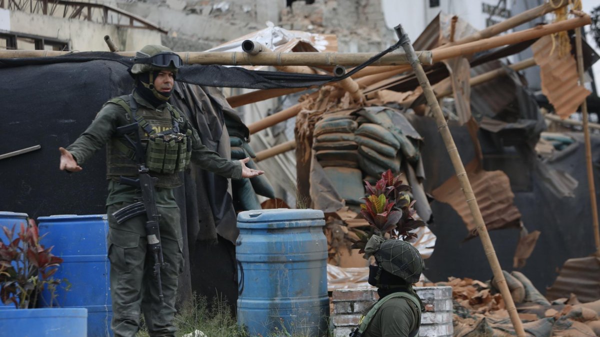 Integrantes de la policía custodian una estación de policía afectada por una explosión este jueves, en Mondomo, Cauca (Colombia).