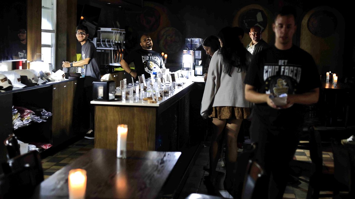 Personas atienden un bar durante un apagón este miércoles, en San Juan (Puerto Rico).