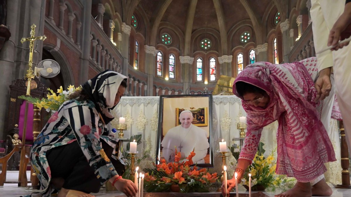 Fieles rinden homenaje junto a un retrato del difunto papa Francisco en la Iglesia Catedral de la Resurrección en Lahore, Pakistán, el 22 de abril de 2025.