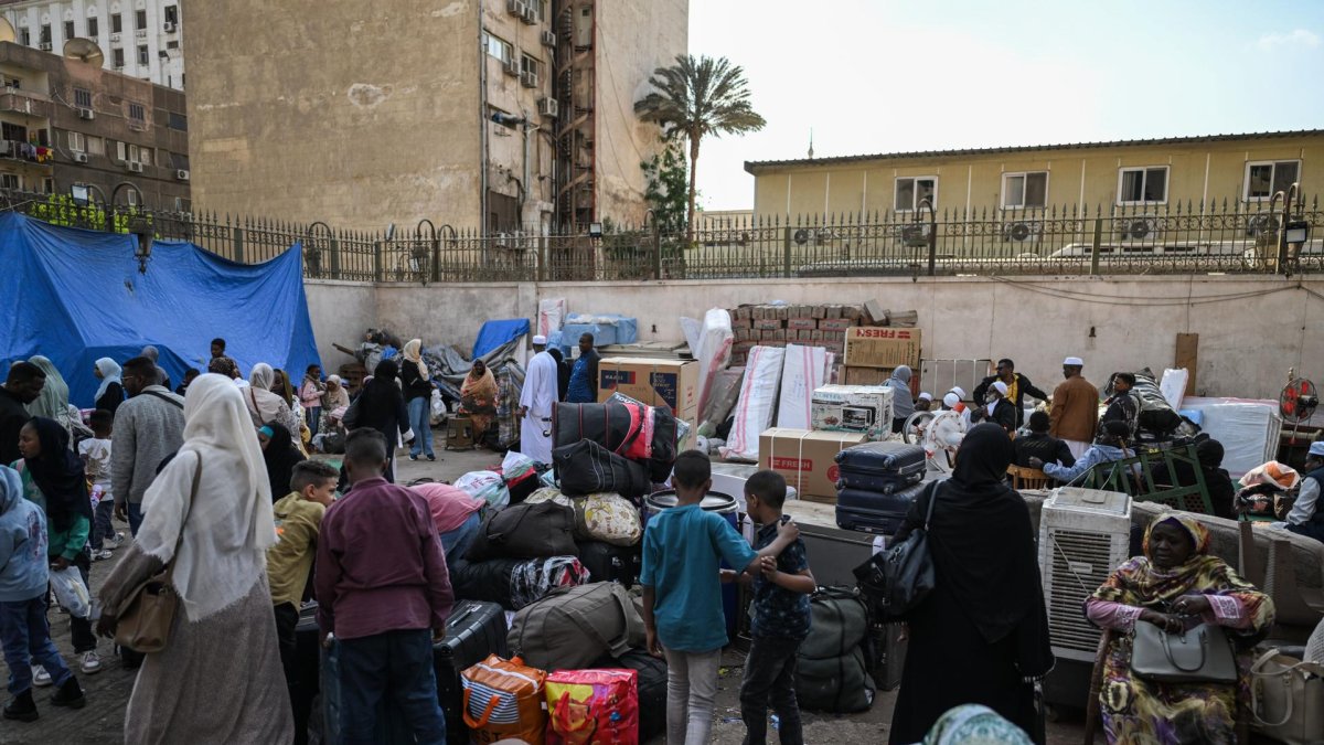Refugiados sudaneses se reúnen en El Cairo en un punto de encuentro para los autobuses organizados para su retorno voluntario de Egipto a Sudán, el 12 de abril de 2025.