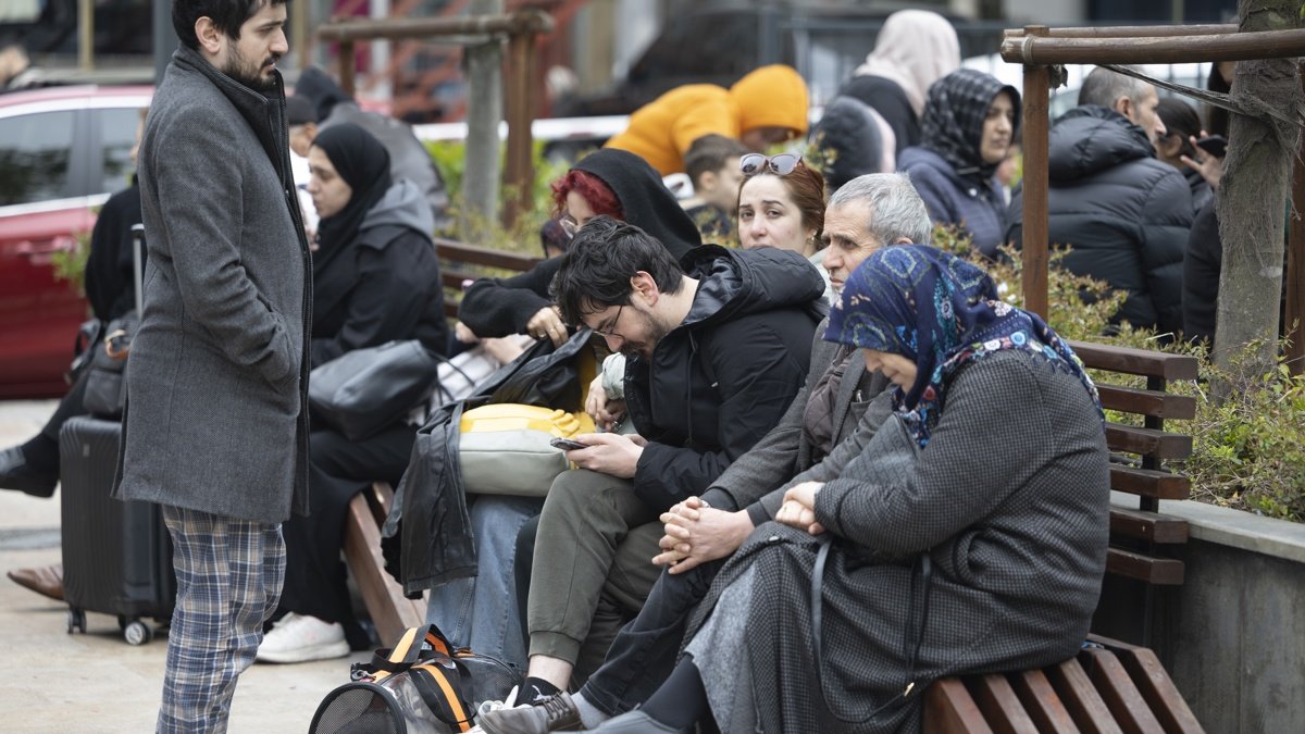 Fotografía de personas con sus pertenencias sentadas en un parque tras un potente terremoto en Estambul, Turquía.