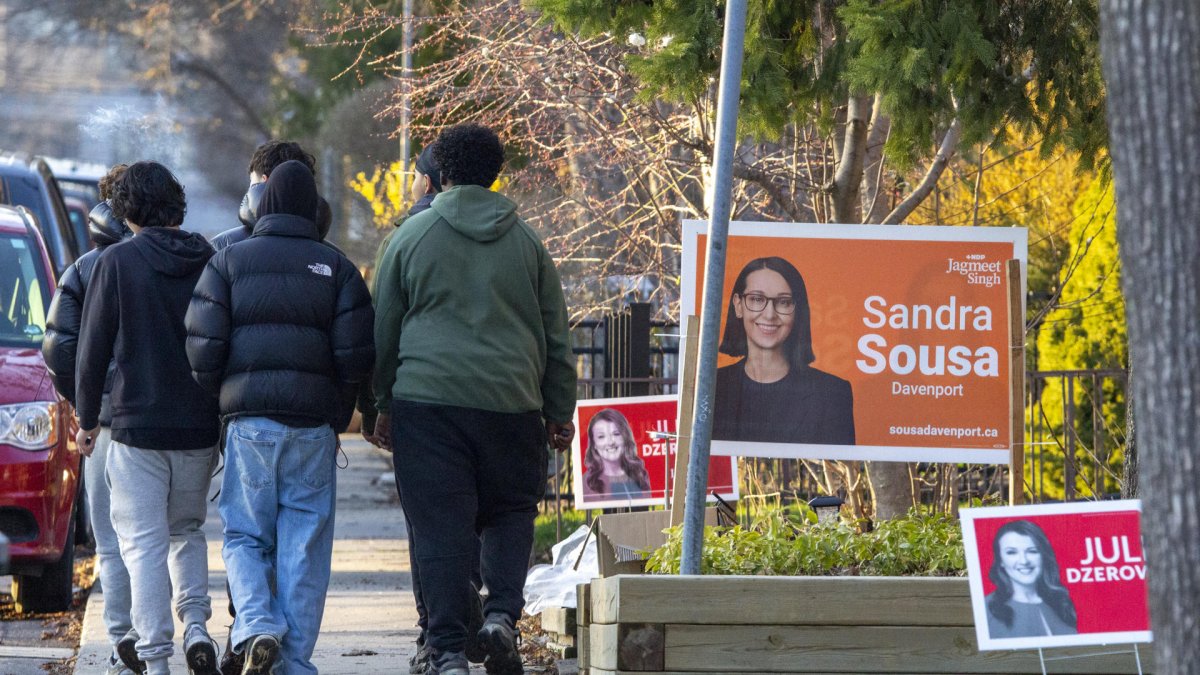 Vista general de un grupo de transeúntes el pasado 21 de abril de 2025 al caminar por calle en la que se ven carteles de propaganda electoral. Toronto, Canadá.