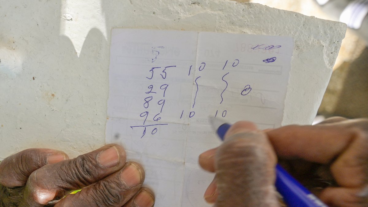 Un hombre escribe en una receta médica el dinero que jugará en Los Ángeles.