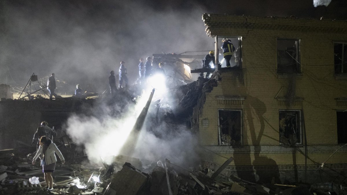 Rescatistas ucranianos trabajan en el lugar donde un cohete impactó la noche del 23 de abril de 2025, contra un edificio residencial en Kiev.