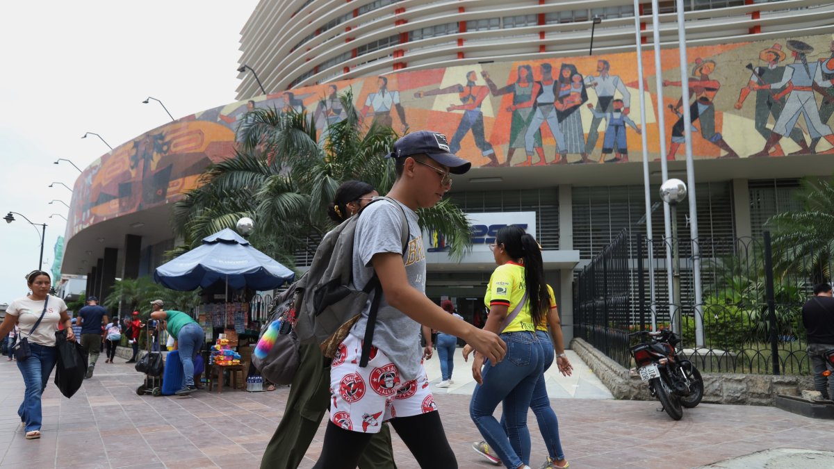 Personas caminan al pie del edificio del Instituto Ecuatoriano de Seguridad Social (IESS), en Guayaquil.