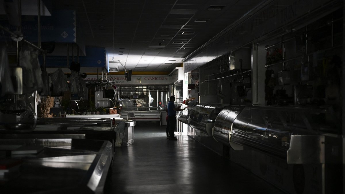 Un hombre y un niño caminan por un mercado local durante un corte de energía masivo en Vigo, noroeste de España, el 28 de abril de 2025.