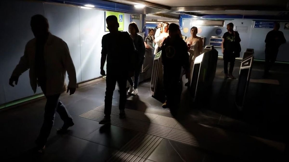 Varias personas en estación de metro madrileña a oscuras tras el apagón eléctrico