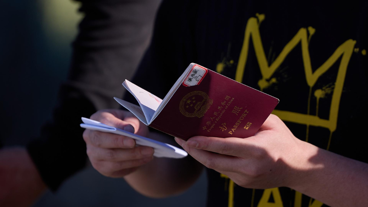 Un migrante sostiene su pasaporte para ser inspeccionado por la Patrulla Fronteriza de EE. UU.
