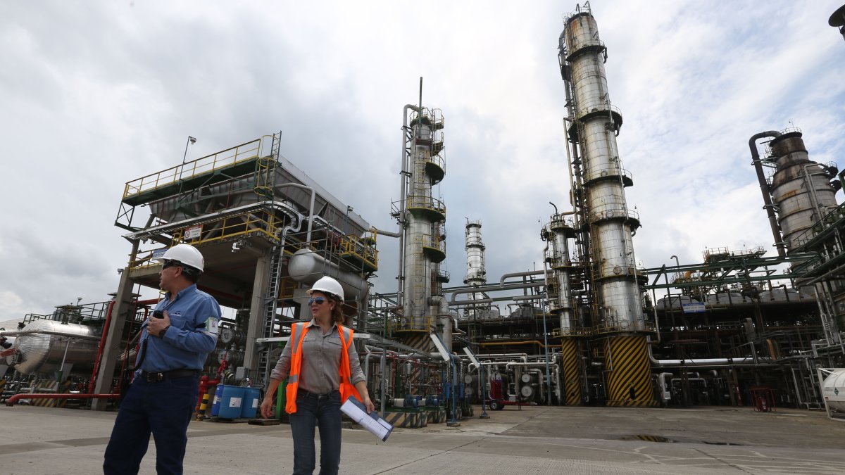 Dos trabajadores caminan en el interior de la Refinería de Esmeraldas.