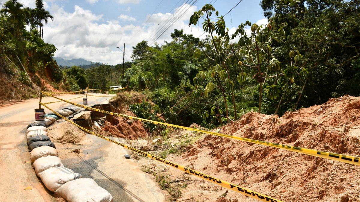 Servicio. Personas tratan de retirar lodo, piedra y otros elementos de vía.