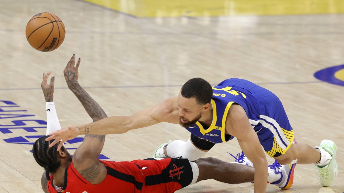 Jalen Green (i) de los Houston Rockets disputa un balón con Stephen Curry de los Warriors de Golden State.