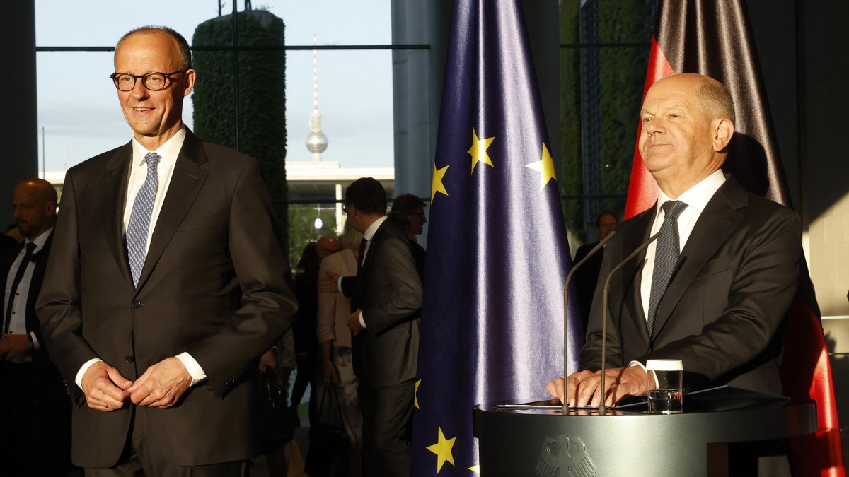 El elegido canciller alemán Friedrich Merz y su predecesor Olaf Scholz habla en una ceremonia de traspaso de poderes en la Cancillería de Berlín.