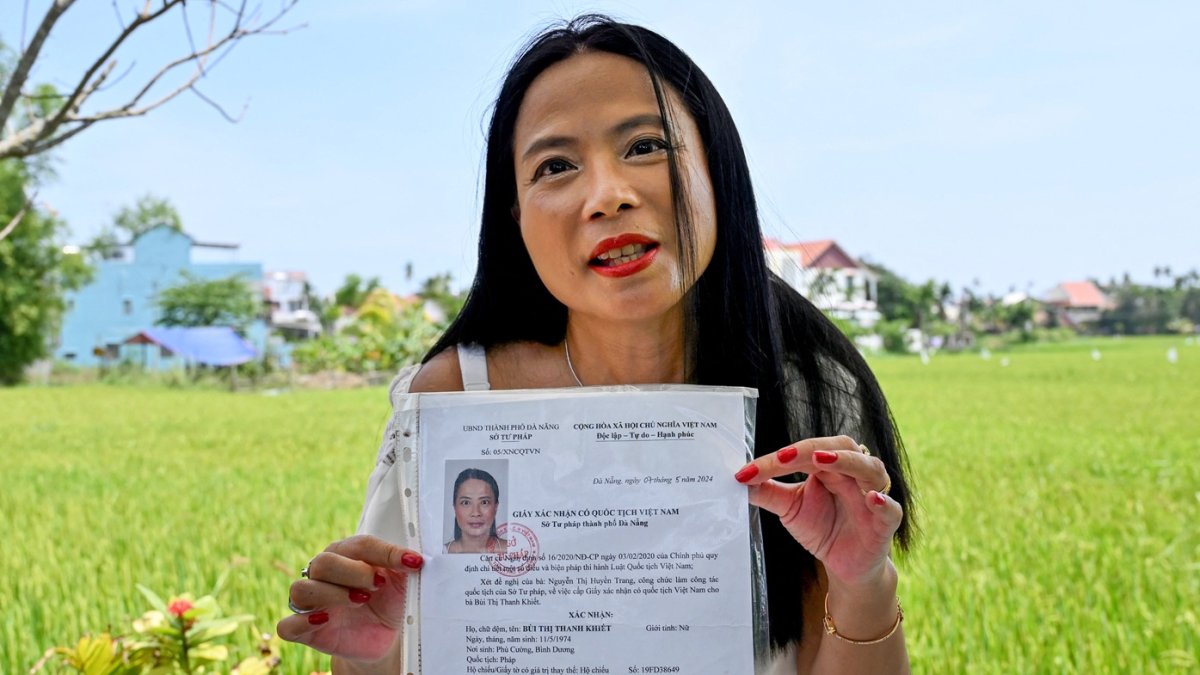 Odile Dussart, quien fue evacuada antes de que termine la guerra de Vietnam hace 50 años, muestra su certificado de nacionalidad vietnamita en su casa recién alquilada en Hoi An.