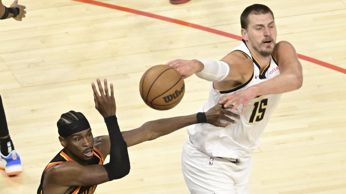 Nikola Jokic por Nuggets (d) disputa un balón ante la estrella de Thunder Shai Gilgeous-Alexander.