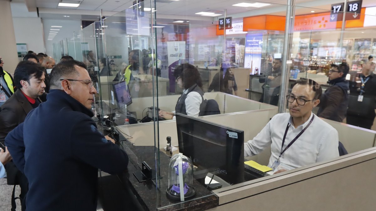 Personal del aeropuerto de Quito revisa el certificado de vacunación en el control migratorio.