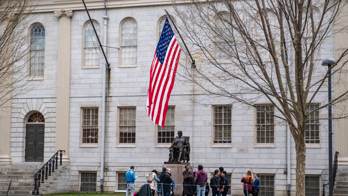 Personas se reúnen alrededor de la estatua de John Harvard en el campus de la Universidad de Harvard en Cambridge, Massachusetts, el 15 de abril de 2025.