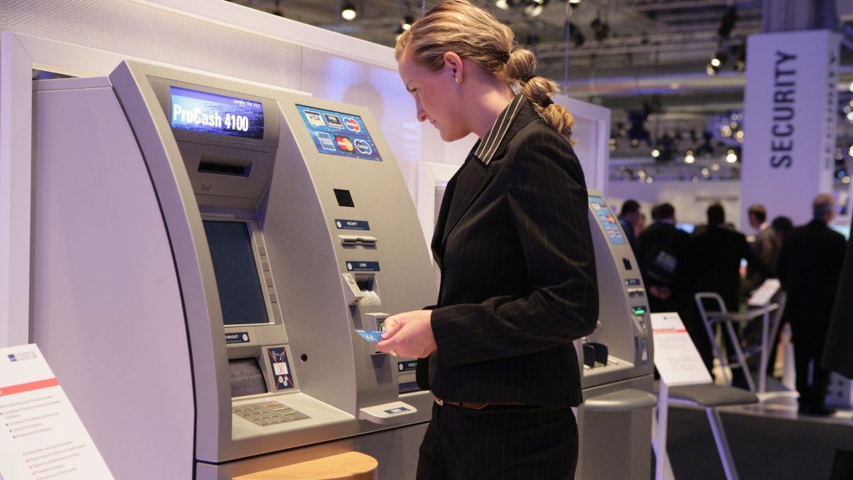 Una persona utiliza un cajero para realizar una transacción bancaria.