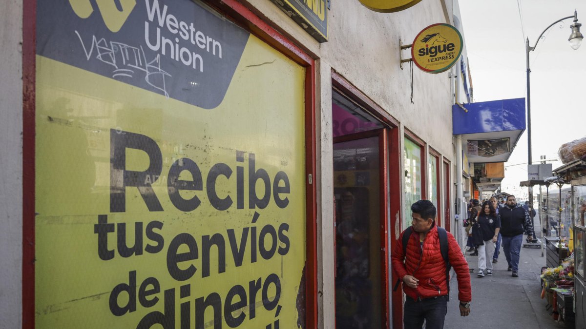 una persona que camina frente a un establecimiento de envío de dinero en Tijuana (México).