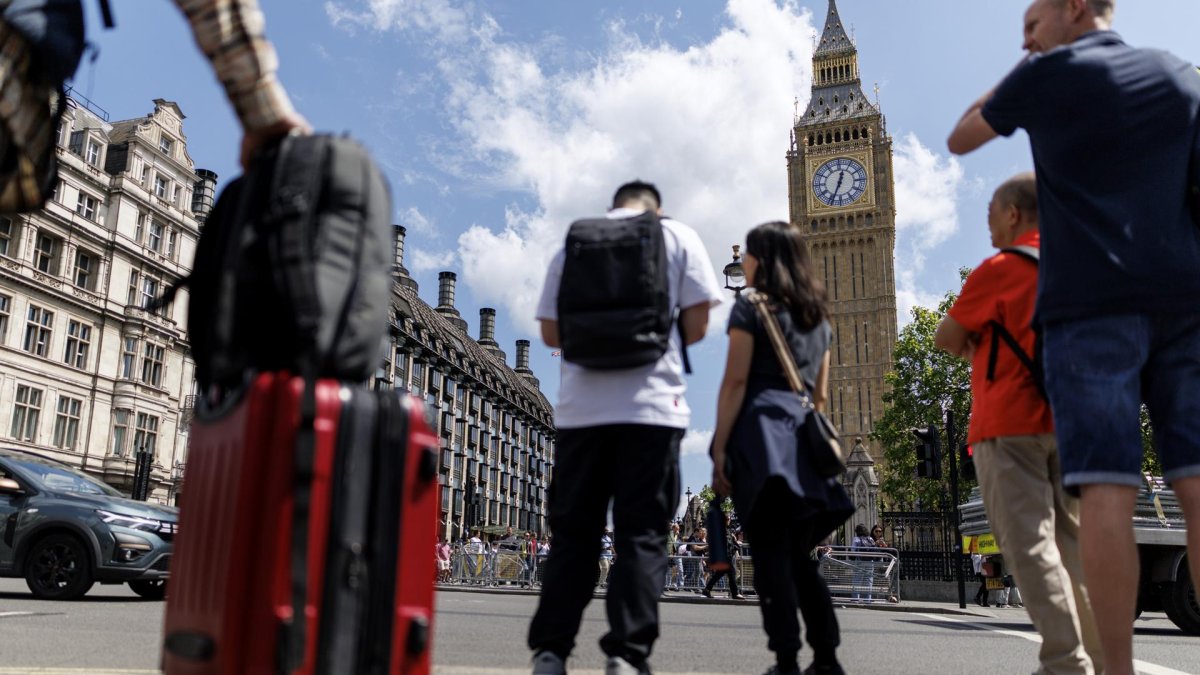 Una persona carga una maleta con la Torre Isabelina, comúnmente conocida como Big Ben, al fondo, en Parliament Square, Londres, Reino Unido, 12 de mayo de 2025.