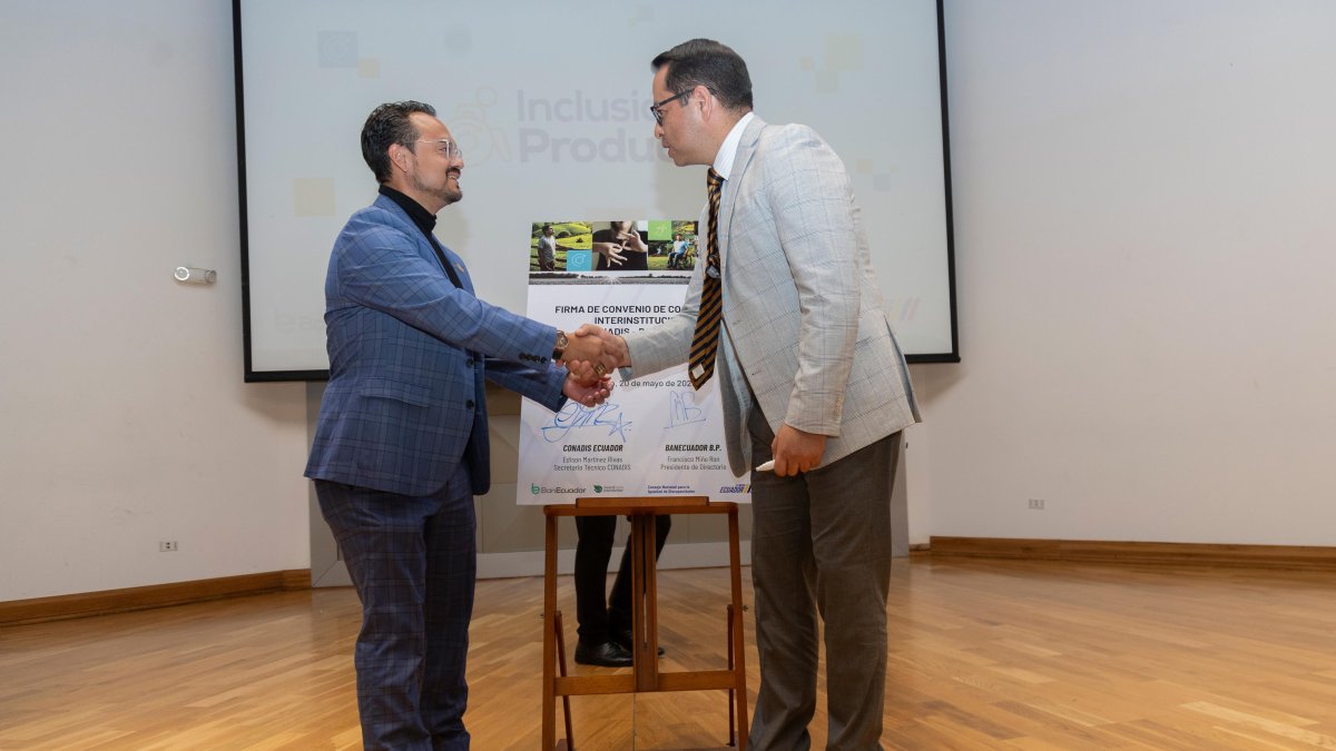 Francisco Miño, presidente del Directorio de BanEcuador y Edison Martínez, secretario Técnico del Conadis firman convenio.