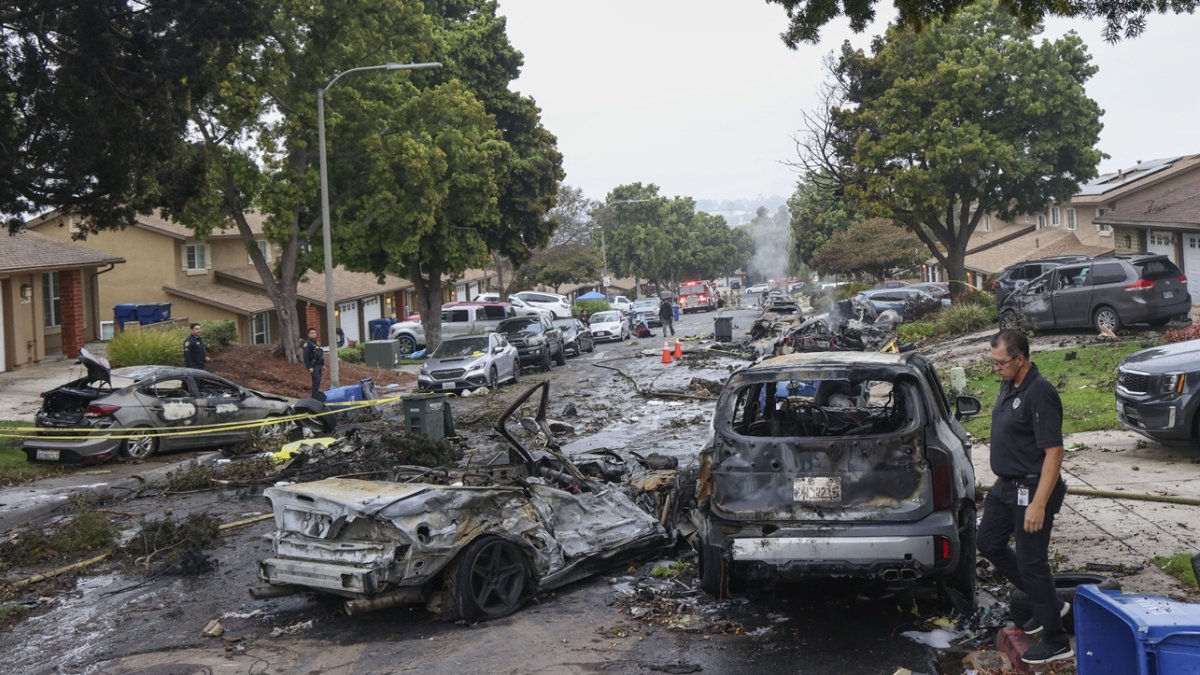 Los investigadores examinan el lugar donde una avioneta se estrelló en una calle residencial de San Diego, California, el 22 de mayo de 2025.