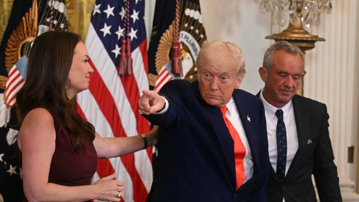 El presidente Donald Trump hace un gesto junto a la secretaria de Agricultura, Brooke Rollins, y el secretario de Salud y Servicios Humanos, Robert F. Kennedy Jr.