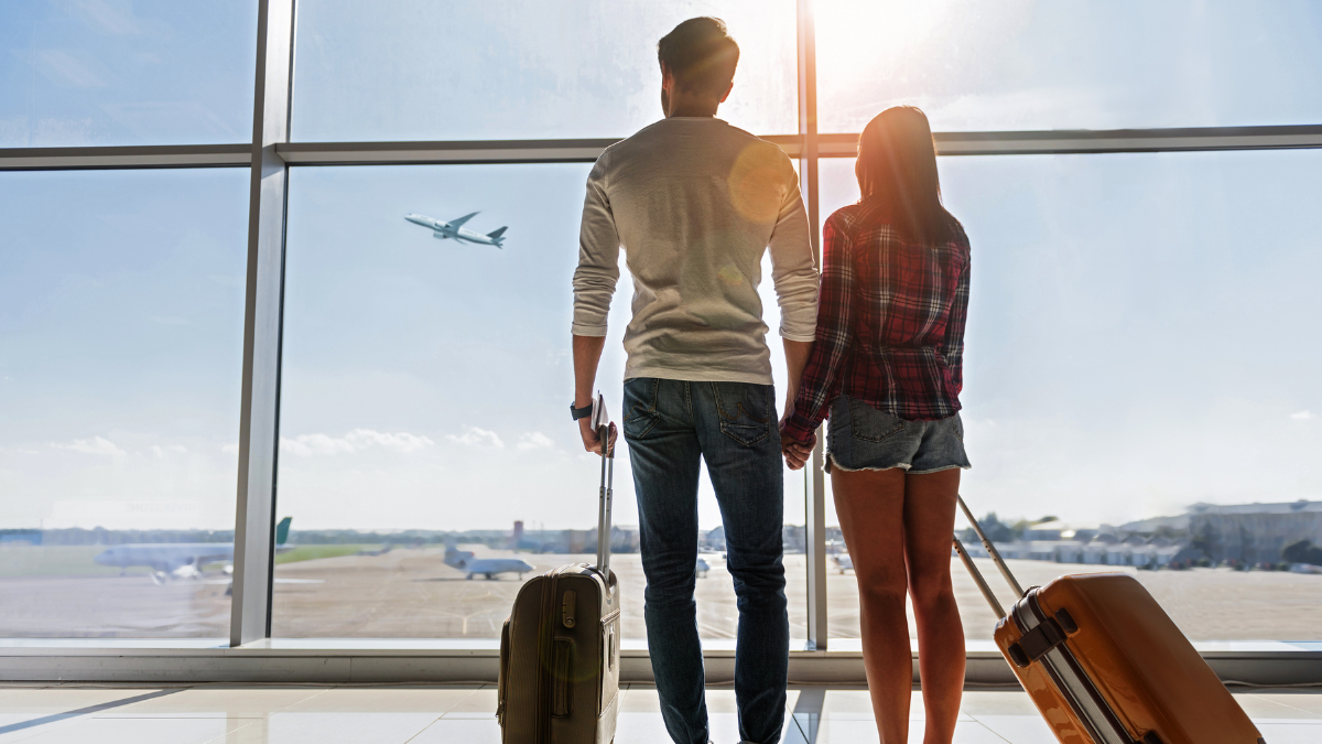 Referencial. Pareja esperando su vuelo en aeropuerto.