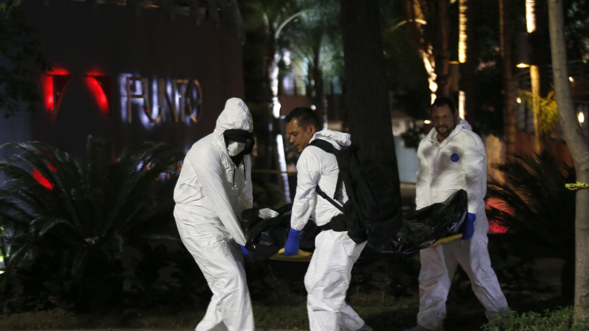 Peritos forenses que cargan un cuerpo que fue encontrado en el estado de Guanajuato, México.