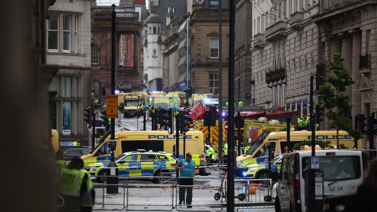 Agentes atienden un incidente en el que un carro chocó con los seguidores del Liverpool durante el desfile de trofeos