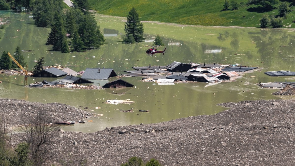 Un helicóptero vuela sobre los escombros y las casas destruidas del pueblo de Blatten, ahora sumergido en el río obstruido Lonza en Wiler, el 30 de mayo de 2025.