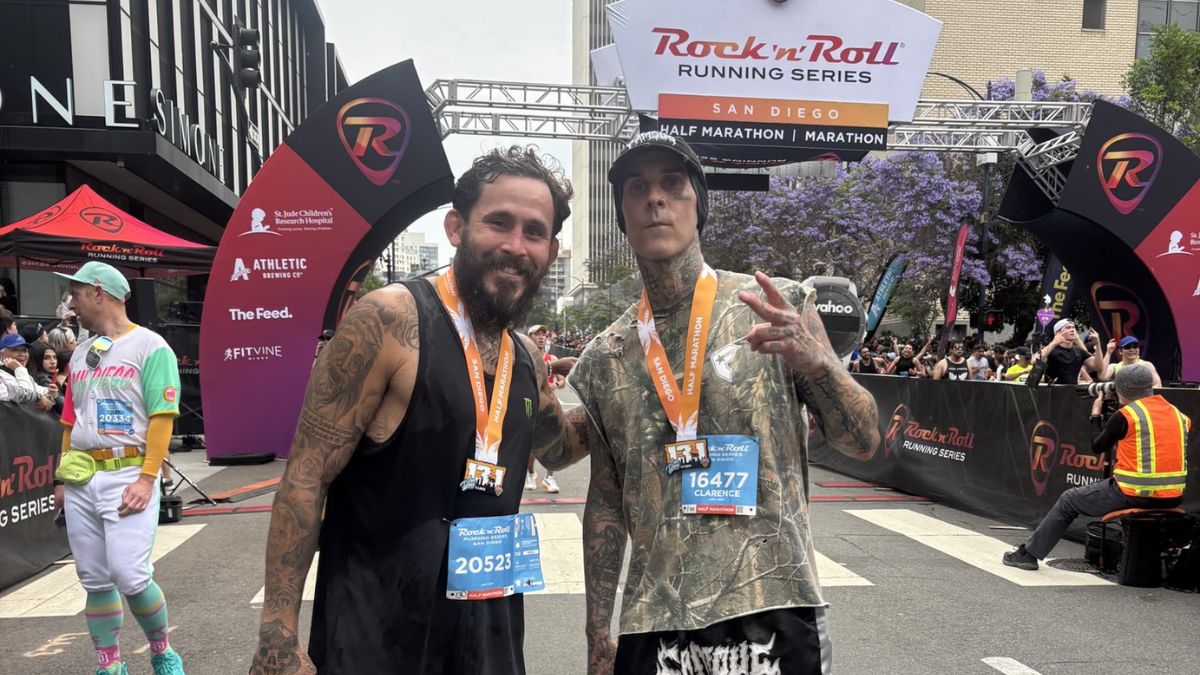 El luchador ecuatoriano Chito Vera y el baterista Travis Barker celebran tras completar juntos la maratón en San Diego