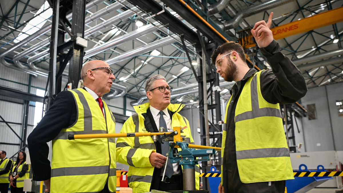 El primer ministro británico, Keir Starmer (centro), y el secretario de Defensa británico, John Healey (izq.), conversan con un miembro del personal en Glasgow, Escocia. el 2 de junio de 2025.