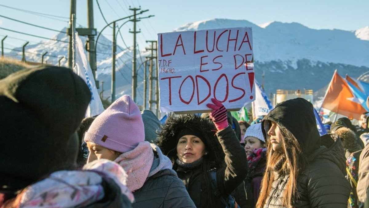 Una mujer sostiene un cartel que dice 