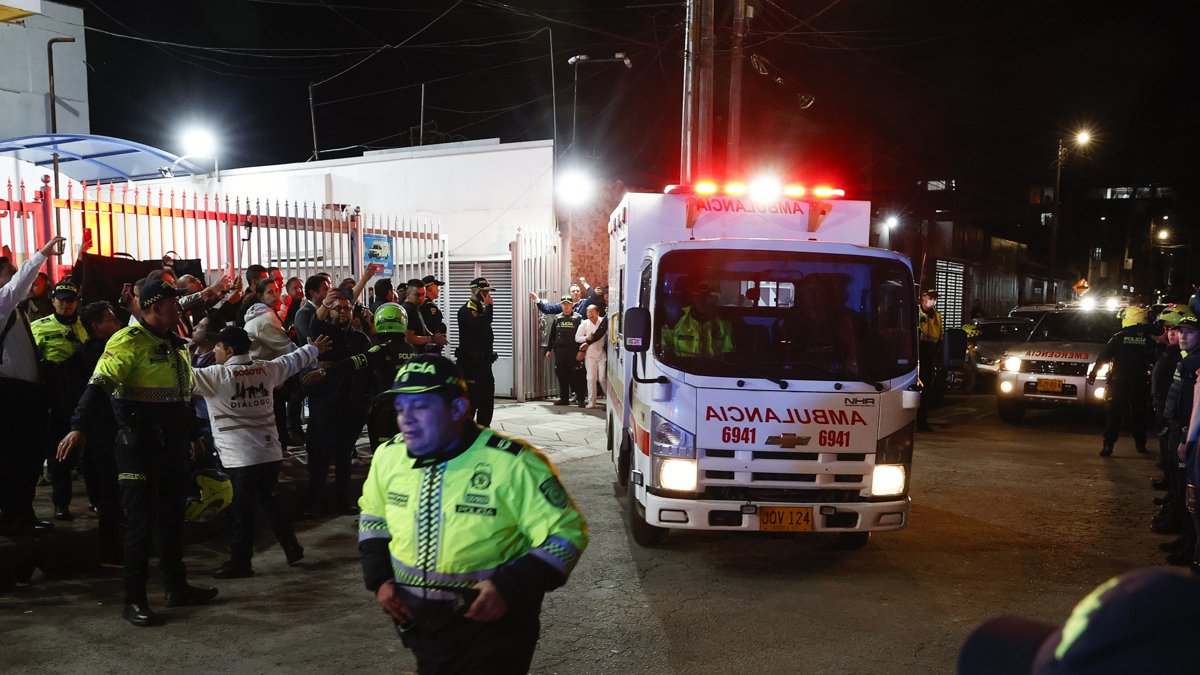 Policías custodian la ambulancia en la que es trasladado el senador Miguel Uribe Turbay, este sábado, en Bogotá (Colombia).